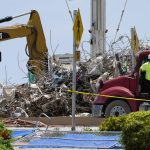 
              A worker waits to load his truck with debris from the rubble of the Champlain Towers South building, as removal and recovery work continues at the site of the partially collapsed condo building, Wednesday, July 14, 2021, in Surfside, Fla. (AP Photo/Lynne Sladky)
            