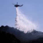 
              A A helicopter makes a water drop to put out hotspots in a wildfire in Topanga, west of Los Angeles, Monday, July 19, 2021. A brush fire scorched about 15 acres in Topanga today, initially threatening some structures before fire crews got the upper hand on the blaze, but one firefighter suffered an unspecified minor injury. (AP Photo/Ringo H.W. Chiu)
            