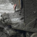 
              A stop sign covered by mud stands near a destroyed house at a mudslide area caused by heavy rains in Atami, Shizuoka Prefecture, west of Tokyo, Monday, July 5, 2021. Rescue workers are slogging through mud and debris looking for dozens unaccounted for after a giant landslide ripped through the Japanese seaside resort town. (AP Photo/Eugene Hoshiko)
            