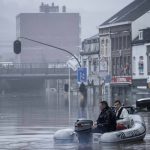 
              People use a rubber raft in floodwaters after the Meuse River broke its banks during heavy flooding in Liege, Belgium, Thursday, July 15, 2021. Heavy rainfall is causing flooding in several provinces in Belgium with rain expected to last until Friday. (AP Photo/Valentin Bianchi)
            