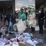 
              Volunteers participate in the cleaning efforts at Soweto's Diepkloof mall outside Johannesburg, South Africa, Thursday July 15, 2021. A massive cleaning effort has started following days of violence in Gauteng and KwaZulu-Natal provinces. The violence erupted last week after Zuma began serving a 15-month sentence for contempt of court for refusing to comply with a court order to testify at a state-backed inquiry investigating allegations of corruption while he was president from 2009 to 2018. (AP Photo/Jerome Delay)
            