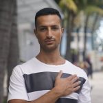 
              Gabriel Nir, who lived on the first floor of the Champlain Towers South condo building that collapsed, poses for a portrait outside the hotel where he is now staying in Surfside, Fla., on Friday, July 2, 2021. He had just finished a late night workout and was in the kitchen cooking salmon. The rest of the family would normally be asleep, but his 15-year-old sister had just returned from babysitting and was in the shower, his dad was out of town and his mom had just come home from an event. They all heard the first thunderous rumble. They knew the building was undergoing construction and had been irritated by the incessant noise, but this felt different. (AP Photo/Gerald Herbert)
            