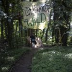 
              A banner reading '"Welcome in Luetzerath forest" hangs in a forest in Luetzerath, Germany, where activists camp to try and stop the construction of a coal mine, Tuesday, July 20, 2021. The village is located just a few hundred meters from a vast pit where German utility giant RWE is extracting lignite coal to burn in nearby power plants.(AP Photo/Bram Janssen)
            
