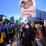 
              Anti-Olympics protesters, right, stage a rally in front of lines of policemen near National Stadium in Tokyo Friday, July 23, 2021.  (Ryosuke Uematsu/Kyodo News via AP)
            