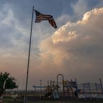 
              Plumes of smoke from the Bootleg Fire rise over a playground, Monday, July 12, 2021, near Bly, Ore. (AP Photo/Nathan Howard)
            