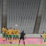 
              Japan's Maya Yoshida, left, takes a penalty kick against South Africa as the stands sit empty during a men's soccer match at the 2020 Summer Olympics, Thursday, July 22, 2021, in Tokyo, Japan. Disputed, locked down and running a year late, the Tokyo Games begin at last on Friday night, a multinational showcase of the finest athletes of a world fragmented by disease — and an event steeped in the political and medical baggage of a relentless pandemic whose presence haunts every Olympic corner. (AP Photo/Shuji Kajiyama)
            
