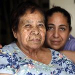 Eugenia Rodriguez, right, and her 84-year-old non-citizen mother, Francisca Perez, pose for a portrait in their house Wednesday, June 30, 2021, in Chicago's Little Village neighborhood. Rodriguez hasn't been eligible for insurance coverage after overstaying a visitor visa from Mexico. She used to wake up every two or three hours at night to check on her mother. Since getting health insurance through the Illinois program, her mother has all the medications she needs. (AP Photo/Shafkat Anowar)
