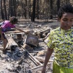 
              Sayyid Bey, left, and his son Nicolas Bey, 11, sift through the remains of their home Thurday, July22, 2021, after it was destroyed by the Bootleg Fire near Bly, Ore. (AP Photo/Nathan Howard)
            