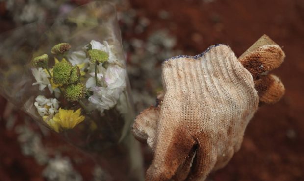 Used gloves belonging to a relative are left at the grave of a COVID-19 victim at a cemetery in Bog...