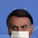 
              FILE - In this Tuesday, May 18, 2021 file photo, Brazil's President Jair Bolsonaro, wearing a mask to curb the spread of COVID-19, attends the launching ceremony of the Asphalt Giants Program, at the Planalto presidential palace, in Brasilia, Brazil. The coronavirus pandemic has upended life around the globe, but it has hasn’t stopped the spread of authoritarianism and extremism. Some researchers believe it may even have accelerated it, but curbing individual freedoms and boosting the reach of the state. Since COVID-19 hit, Hungary has banned children from being told about homosexuality. China shut Hong Kong’s last pro-democracy newspaper. Brazil’s president has extolled dictatorship. Belarus has hijacked a passenger plane. A Cambodian human rights lawyer calls the pandemic “a dictator's dream opportunity.” But there are also resistance movements, as protesters from Hungary to Brazil take to the streets to defend democracy.  (AP Photo/Eraldo Peres, File)
            