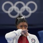 
              Simone Biles, of the United States, watches gymnasts perform after an apparent injury, at the 2020 Summer Olympics, Tuesday, July 27, 2021, in Tokyo. Biles withdrew from the team finals. (AP Photo/Ashley Landis)
            