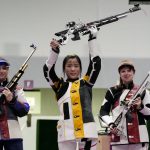 
              Yaxuan Xiong, center, of China, holds her rifle aloft after winning a gold medal in the women's 10-meter air rifle at the Asaka Shooting Range in the 2020 Summer Olympics, Saturday, July 24, 2021, in Tokyo, Japan. Anastasiia Galashina, left, of the Russian Olympic Committee, took the silver medal and Nina Christen, of Switzerland took the bronze medal .(AP Photo/Alex Brandon)
            