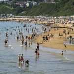 
              People enjoy the weather on Bournemouth beach in Dorset, England, Monday July 19, 2021. (Steve Parsons/PA via AP)
            