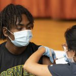 
              Zhaequan Brown, 19, gets the Pfizer COVID-19 vaccine at Lehman High School, Tuesday, July 27, 2021, in New York. The Centers for Disease Control and Prevention is urging everyone in K-12 schools to wear a mask when they return to class, regardless of vaccination status. (AP Photo/Mark Lennihan)
            