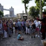 
              On what some have called "Freedom Day", marking the end of coronavirus restrictions in England, visitors listen as Yeoman Warder Barney Chandler leading the first tour of the Tower of London in 16 months since the start of the coronavirus outbreak, in London, Monday, July 19, 2021. Beginning Monday, face masks will no longer be legally required and with social distancing rules shelved, but mask rules will remain for passengers on the London transport network.  (AP Photo/Matt Dunham)
            