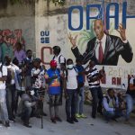 
              Journalists gather near a mural featuring Haitian President Jovenel Moise, near the leader’s residence where he was killed by gunmen in the early morning hours, and his wife was wounded, in Port-au-Prince, Haiti, Wednesday, July 7, 2021. Claude Joseph, the interim prime minister, confirmed the killing and said the police and military were in control of security in Haiti. (AP Photo/Joseph Odelyn)
            