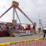 
              FILE- In this July 27, 2017 file photo, an Ohio State Highway Patrol trooper removes a ground spike in front of the Fire Ball ride at the Ohio State Fair, in Columbus, Ohio. Ohio has beefed up its amusement ride inspections four years after the ride broke apart at the 2017 Ohio State Fair and killed a high school student and injured several others. But some ride operators and festival organizers say the state's inspectors are overreaching and shutting down rides over issues that aren't safety-related. (AP Photo/Jay LaPrete, File)
            