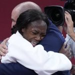 
              Clarisse Agbegnenou of France, left celebrates with her coach Larbi Benboudaoud after defeating Tina Trstenjak of Slovenia, unseen, in the women -63kg final of the judo match at the 2020 Summer Olympics in Tokyo, Japan, Tuesday, July 27, 2021. (AP Photo/Vincent Thian)
            