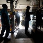 
              Customers shop in a convenience store that opened with no electricity after the effects the effects of Hurricane Ida knocked out power in the area, Monday, Aug. 30, 2021, in Nhew Orleans, La. (AP Photo/Eric Gay)
            
