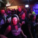 
              People sing and dance at a rock concert on Thursday, Aug. 5, 2021, in Sturgis, S.D. The Sturgis Motorcycle Rally starts Friday, even as coronavirus cases rise in South Dakota. (AP Photo/Stephen Groves)
            