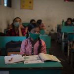 Students attend a class on the first day of partial reopening of schools in Noida, a suburb of New Delhi, India, Wednesday, Sept. 1, 2021. Many students in India will be able to step inside a classroom for the first time in nearly 18 months from Wednesday, as authorities have given the green light to partially reopen schools despite apprehension from some parents and signs that coronavirus infections are picking up again. Schools and colleges in least six states will reopen in a gradual manner with health measures in place throughout September. In New Delhi, all staff must be vaccinated and class sizes will be capped at 50% with staggered seating and sanitized desks. (AP Photo/Altaf Qadri)