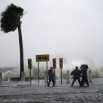 A news crew reports on the edge of Lake Pontchartrain ahead of approaching Hurricane Ida in New Orleans, Sunday, Aug. 29, 2021. (AP Photo/Gerald Herbert)