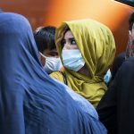 
              Families evacuated from Kabul, Afghanistan, wait to board a bus after they arrived at Washington Dulles International Airport, in Chantilly, Va., on Wednesday, Aug. 25, 2021. (AP Photo/Jose Luis Magana)
            