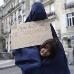 
              A woman wearing a burqa and holding a poster reading "Do not forget us after Aug.31" attends a gathering in a show of solidarity with women from Afghanistan, Saturday, Aug. 28, 2021 in Paris. France ended evacuation operations on Friday and its team at the makeshift French Embassy at Kabul's airport pulled up stakes. (AP Photo/Adrienne Surprenant)
            