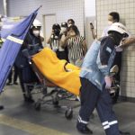 
              Rescuers carry an injured passenger on  stretcher at Soshigaya Okura Station after stabbing on a commuter train, in Tokyo Friday night, Aug. 6, 2021. A man with a knife attacked 10 passengers on a commuter train in Tokyo on Friday and was arrested by police after fleeing, fire department officials and news reports said. (Kyodo News via AP)
            