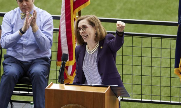 FILE - In this Wednesday, June 30, 2021, file photo, Oregon Gov. Kate Brown pumps her fist while an...
