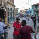 
              Men chat at a street in Jeremie, Haiti, Wednesday, Aug. 18, 2021, four days after the city was struck by a 7.2-magnitude earthquake. (AP Photo/Matias Delacroix)
            