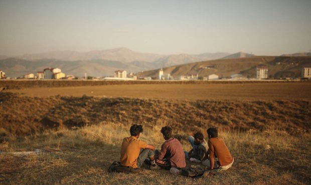 Young men who say they deserted the Afghan military and fled to Turkey through Iran sit in the coun...
