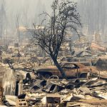 
              Homes and cars destroyed by the Dixie Fire line central Greenville on Thursday, Aug. 5, 2021, in Plumas County, Calif. (AP Photo/Noah Berger)
            