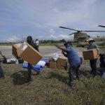 
              Residents help Team Rubicon's disaster response team unload aid at the airport from a U.S. Army helicopter to take to the hospital where the team is treating residents injured in the 7.2 magnitude earthquake in Les Cayes, Haiti, Thursday, Aug. 19, 2021. (AP Photo/Fernando Llano)
            