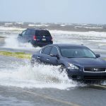 
              Cars drive through flood waters along route 90 as outer bands of Hurricane Ida arrive Sunday, Aug. 29, 2021, in Gulfport, Miss. (AP Photo/Steve Helber)
            