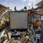 
              Jacob Hodges, right, and his brother Jeremy Hodges work to clear debris from their storage unit which was destroyed by Hurricane Ida, Monday, Aug. 30, 2021, in Houma, La. (AP Photo/David J. Phillip)
            