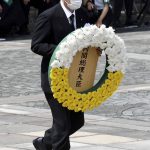 Japan's Prime Minister Yoshihide Suga offers a wreath during a ceremony at Nagasaki Peace Park in Nagasaki, southern Japan Monday, Aug. 9, 2021. The Japanese city of Nagasaki on Monday marked its 76th anniversary of the U.S. atomic bombing. (Kyodo News via AP)