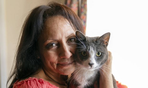 In this Wednesday, June 30, 2021, photo Veronica Perez hugs her cat, Brooklyn, at her new home at a...