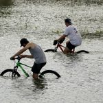 
              Cyclists peddle through floodwaters caused by the effects of Hurricane Ida near the New Orleans Marina, Monday, Aug. 30, 2021, in New Orleans, La. (AP Photo/Eric Gay)
            
