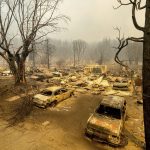 
              This photo shows cars and homes destroyed by the Dixie Fire line central Greenville on Thursday, Aug. 5, 2021, in Plumas County, Calif. (AP Photo/Noah Berger)
            