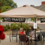 
              People sit under a tent at the the Green Valley Community Church evacuation shelter on Thursday, Aug. 19, 2021, in Placerville, Calif., as the Caldor Fire continues to burn. (AP Photo/Ethan Swope)
            