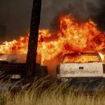 
              Flames consume vehicles in a wrecking yard as the Dixie Fire burns in Chester, Calif., on Wednesday, Aug. 4, 2021. The region is under red flag fire warnings due to dry, windy conditions. (AP Photo/Noah Berger)
            