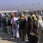 
              Afghan and Pakistani nationals stand in a queue and wait their turn to enter into Afghanistan through a border crossing point, in Chaman, Pakistan, Saturday, Aug. 21, 2021. (AP Photo)
            