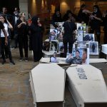 
              Ibrahim Hoteit, 51, left, the brother of Tharwat Hoteit, who was killed in last year's massive blast at Beirut's seaport, leads a chant as relatives of others who were killed, stand next to empty coffins with portraits of the dead, during a protest outside the home of caretaker Interior Minister Mohamed Fehmi, in Beirut, Lebanon, Tuesday, July 13, 2021. A year after the deadly blast, families of the victims are consumed with winning justice for their loved ones and punishing Lebanon's political elite, blamed for causing the disaster through their corruption and neglect. (AP Photo/Bilal Hussein)
            