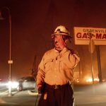 
              Battalion Chief Sergio Mora rubs his face as the Dixie Fire tears through the Greenville community of Plumas County, Calif., on Wednesday, Aug. 4, 2021. The fire leveled multiple historic buildings and dozens of homes in central Greenville. (AP Photo/Noah Berger)
            
