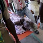 
              Boy scouts carry on a stretcher, a woman injured in Saturday's 7.2-magnitude earthquake, at the Saint Antoine hospital in Jeremie, Haiti, Wednesday, Aug. 18, 2021. (AP Photo/Matias Delacroix)
            
