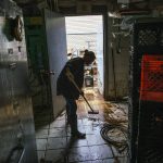 
              A worker cleans inside Four Boys Ice Cream store during the passing of Tropical Storm Henri in Jamesburg, N.J., Monday, Aug. 23, 2021. (AP Photo/Eduardo Munoz Alvarez)
            