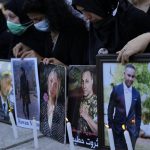 
              Relatives of victims of the Aug. 4, 2020, Beirut port explosion light candles and hold portraits of their loved ones, in Beirut, Lebanon, Sunday, July 4, 2021. A year after the deadly blast, families of the victims are consumed with winning justice for their loved ones and punishing Lebanon's political elite, blamed for causing the disaster through their corruption and neglect. (AP Photo/Hassan Ammar)
            