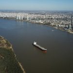
              A grain ship sits anchored in the middle of the Parana River as it waits its turn to enter the port of Rosario, Argentina, Thursday, July 29, 2021. Ports along the Parana River are the largest exporters of grain in the world and ships have had to reduce their cargo capacity to be able to navigate the river´s falling water levels. (AP Photo/Victor Caivano)
            