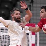 
              Egypt's Ahmed Elahmar, right, and France's Luka Karabatic challenge for the ball during the men's semifinal handball match between France and Egypt at the 2020 Summer Olympics, Thursday, Aug. 5, 2021, in Tokyo, Japan. (AP Photo/Pavel Golovkin)
            